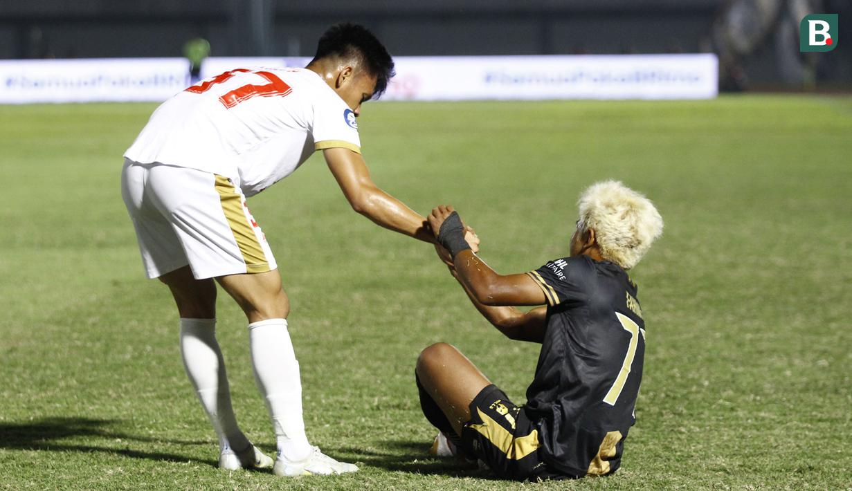 Pemain PSM Makassar, Muhammad Dzaki Asraf Huwaidi (kiri) membantu pemain Dewa United FC, Mochammad Fahmi Al Ayyubi bangkit usai keduanya bertabrakan dipinggir lapangan saat laga pekan ke-10 BRI Liga 1 2022/2023 antara Dewa United FC melawan PSM Makassar di Stadion Indomilk Arena, Tangerang, Kamis (15/9/2022). (Bola.com/Muhammad Aldiansyah)