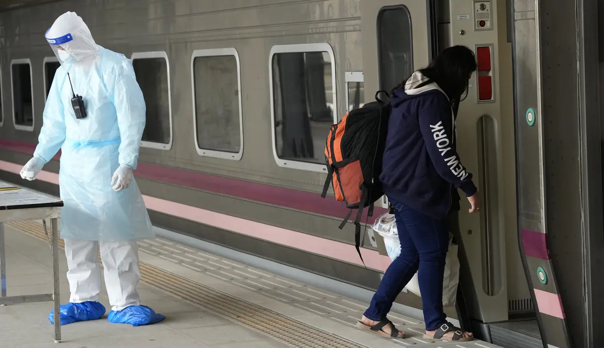 Seorang pasien COVID-19 naik kereta di Stasiun Rangsit, Provinsi Pathum Thani, Thailand, Selasa (27/7/2021). Pengiriman pasien COVID-19 dari Bangkok ke kota asal mereka ini untuk meringankan beban sistem medis ibu kota yang kewalahan. (AP Photo/Sakchai Lalit)