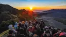 Pengunjung memadati Love Hill menunggu matari terbit di Bromo, Jawa Timur. Gunung Bromo dikenal sebagai salah satu lanskap paling magis di Indonesia. Perpaduan antara gunung megah, lautan pasir luas, serta kabut tipis yang menari di pagi hari menciptakan panorama emas yang sulit ditandingi. (merdeka.com/Arie Basuki)