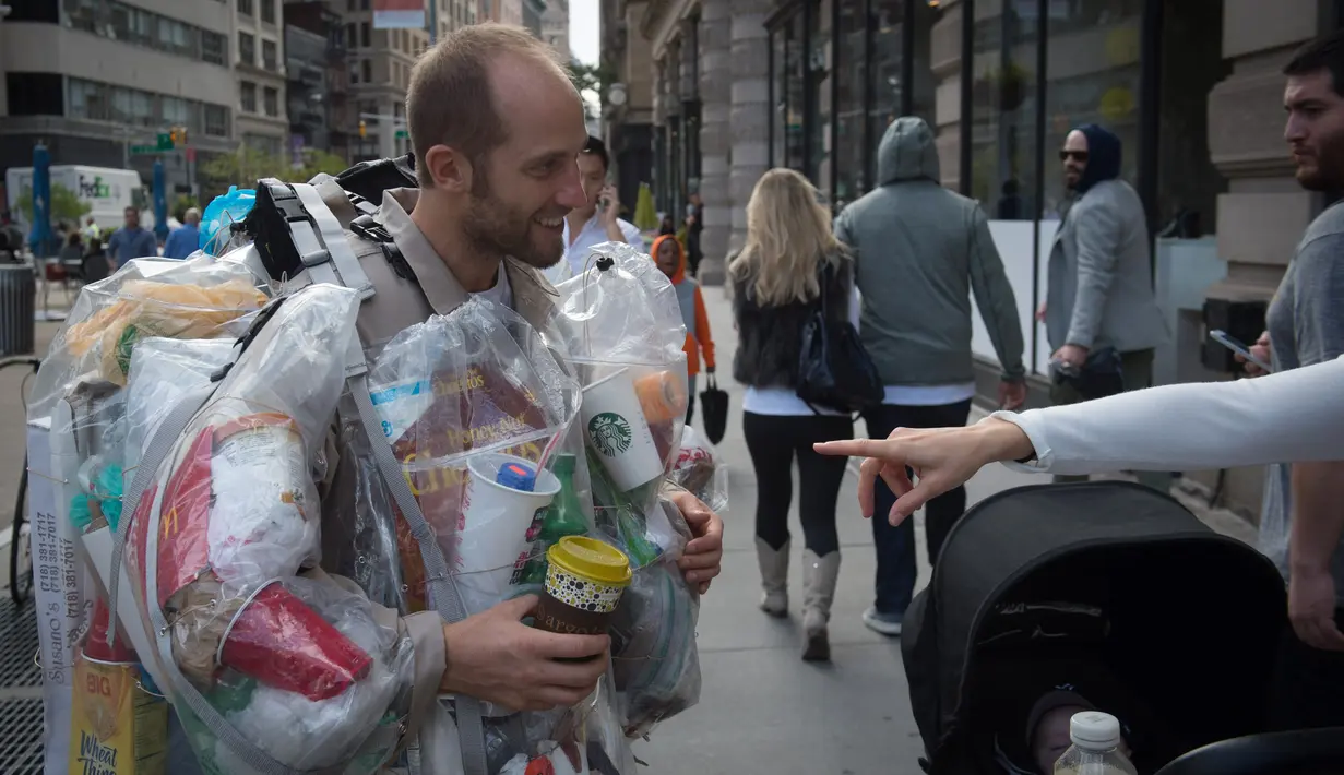 Seorang warga menanyakan kantung-kantung plastik berisi sampah-sampah pada tubuh Rob Greenfield di New York, AS, 4 September 2016. Aktivis lingkungan itu bertekad untuk memakai semua sampah yang ia hasilkan selama 30 hari. (AFP Photo/Bryan R. Smith)