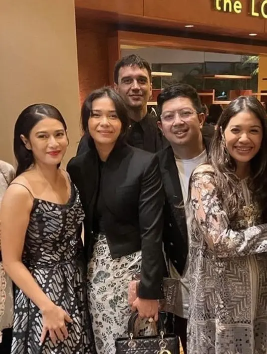 Adinia Wirasti tampil dengan atasan hitam lengan panjang dipadukan kain batik lilit, sambil membawa tas Dior hitamnya. [@amaliawirjono]