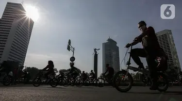 Warga berolahraga di area Car Free Day (CFD) kawasan MH Thamrin, Jakarta, Minggu (21/6/2020). Hari ini adalah kali pertama digelarnya CFD Jakarta di sepanjang Jalan Sudirman - Thmarin saat Pembatasan Sosial Berskala Besar (PSBB) Masa Transisi. (Liputan6.com/Johan Tallo)