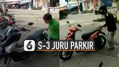 Seorang pria unjuk keahlian memarkirkan sepeda motor dengan satu tangan.