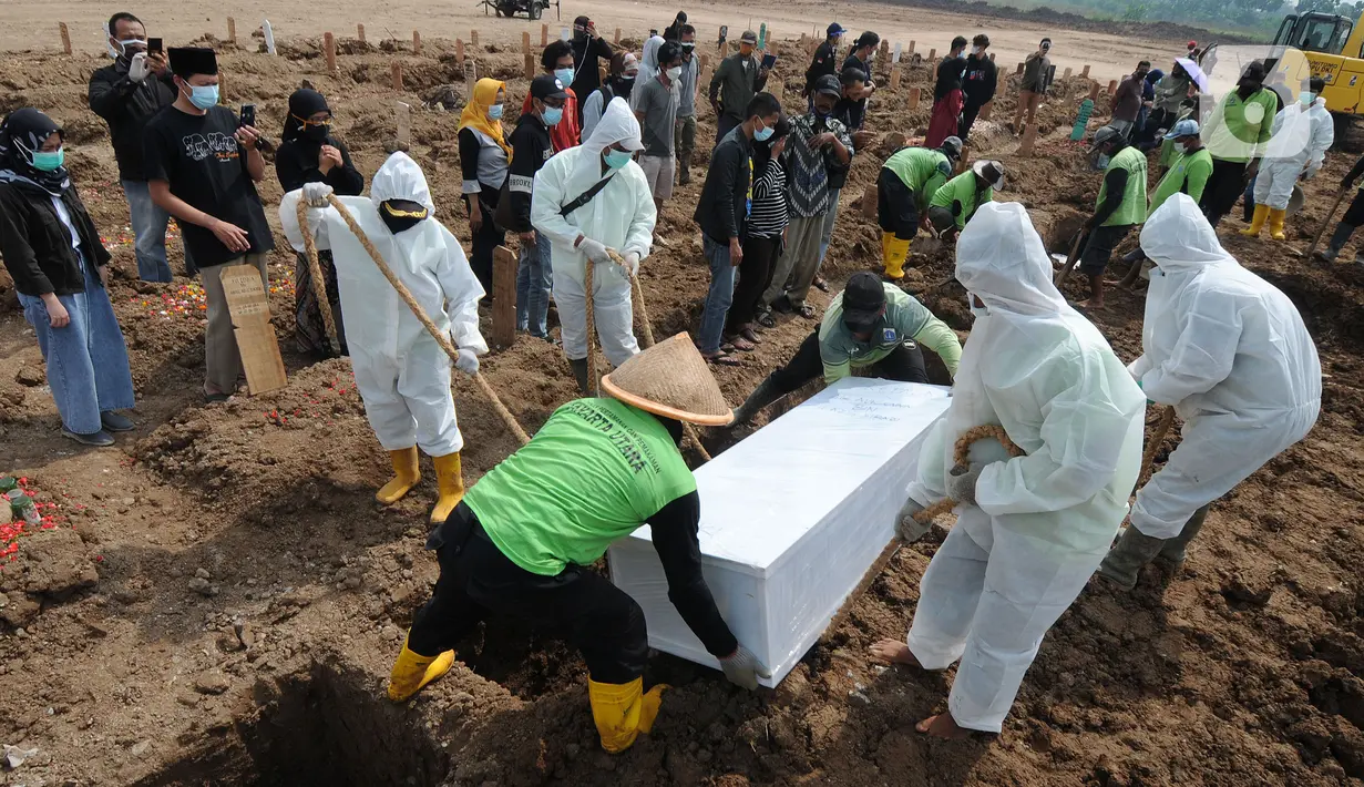 Petugas memakamkan jenazah korban Covid-19 di TPU Rorotan, Jakarta Utara, Senin (28/06/20121). Sudah lebih dari dua pekan petugas kewalahan memakamkan korban covid-19, dimana dalam seharinya mereka memakamkan rata-rata 110 jenazah dari pagi hingga pukul 23.00. (merdelka.com/Arie Basuki)