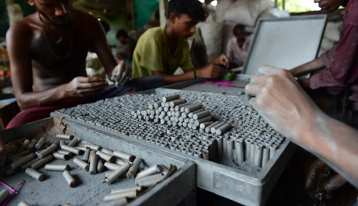 Pekerja membuat petasan di bengkel jelang festival Diwali di pinggiran Ahmedabad, India (21/9/2022). Diwali, festival keagamaan terpenting di negara itu, akan digelar pada 24 Oktober mendatang. (AFP/Sam Panthaky)