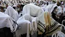 Pemandangan saat ribuan umat Yahudi menggelar doa di Tembok Barat Kota Tua Yerusalem, Senin (2/4). Ritual mengingat penderitaan bangsa Israel saat eksodus dari Mesir ini dilakukan dengan menahan diri dari makan produk makanan beragi. (MENAHEM KAHANA/AFP)