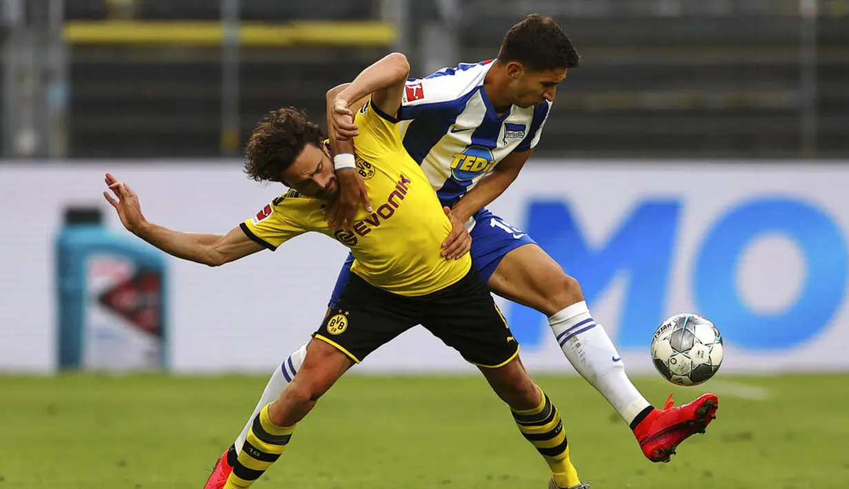 Pemain Borussia Dortmund, Thomas Delaney, berebut bola dengan pemain Hertha Berlin, Marko Grujic, pada laga Bundesliga di Stadion di Signal Iduna Park, Sabtu (6/6/2020). Borussia Dortmund menang 1-0 atas Hertha Berlin. (AP/Lars Baron)