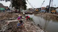 Warga korban gusuran memunguti puing bangunan yang dapat dijual kembali di bantaran Sungai Ciliwung, Bukit Duri, Jakarta, Selasa (20/1). (Liputan6.com/Gempur M Surya)