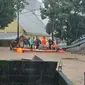 Personil Polri ikut mengevakuasi warga terdampak bencana banjir di Kota Manado, JUmat (27/1/2023).