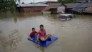 Warga menggunakan rakit menerobos banjir yang merendam di kecamatan Mawlamyine, negara bagian Mon, Myanmar (18/6). Hujan merendam rumah warga dan memaksa ratusan orang mengungsi. (AFP PHOTO / Ye Aung Thu)