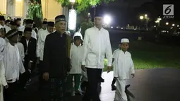 Presiden Joko Widodo (Jokowi) bersama anak-anak yatim se-Jabodetabek berjalan beriringan menuju masjid yang berada di halaman Istana, Jakarta, Senin (12/6). (Liputan6.com/Angga Yuniar)