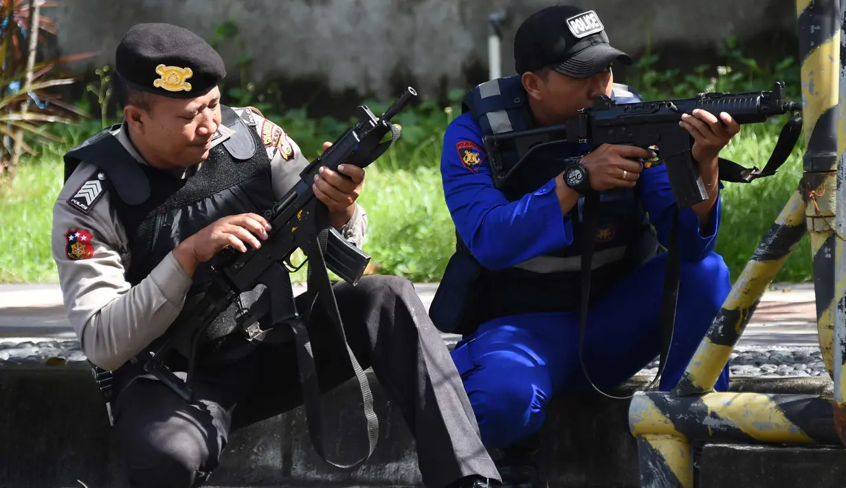 Polisi antiteror Indonesia mempersiapkan senjata selama latihan penanggulangan teror di Pelabuhan Benoa, Bali, (8/3). Simulasi penanggulangan teror ini untuk memastikan pelaksanaan prosedur standar penanganan terorisme. (AFP Photo/Sonny Tumbelaka)