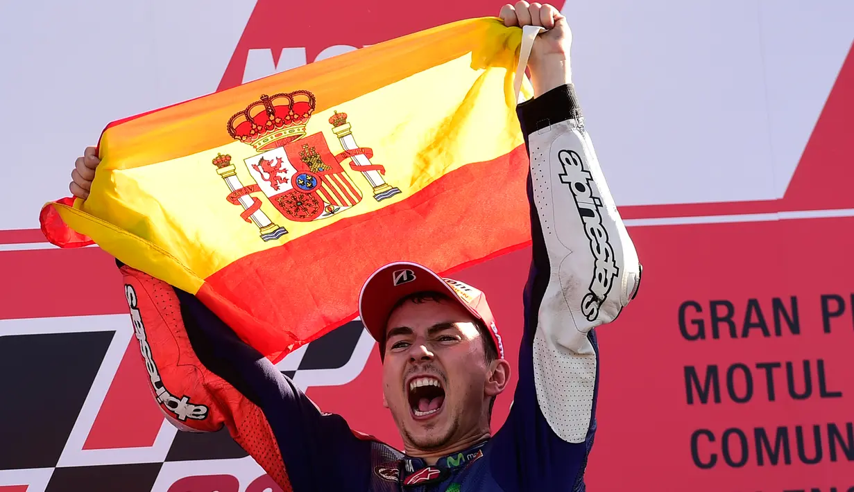 Jorge Lorenzo melakukan selebrasi mengibarkan bendera kebangsaannya, Spanyol. usai sukses menjadi juara dunia MotoGP 2015 di seri terakhir Grand Prix Valencia di Sirkuit Ricardo Tormo di Valencia, Spanyol, Minggu (8/11). (REUTERS/Heino Kalis)
