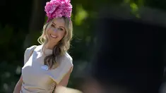 Naomi Rees mengenakan topi bunga berpose setelah tiba untuk hari pertama acara balap kuda Royal Ascot, di Ascot Racecourse, di Ascot, Inggris, Selasa (14/6/2022). (AP Photo/Alastair Grant)