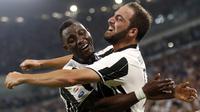 Striker Juventus, Gonzalo Higuain (kanan) saat merayakan golnya ke gawang Fiorentina pada pertandingan Serie A, di Juventus Stadium, Sabtu atau Minggu (21/8/2016) dini hari WIB. (AFP/Marco Bertorello). 