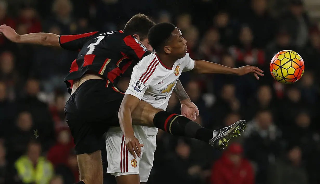 Penyerang MU, Anthony Martial, berebut bola dengan bek Bournemouth, Steve Cook, pada laga Liga Premier Inggris di Stadion Vatality, Inggris, Sabtu (12/12/2015). (AFP/Ian Kington)