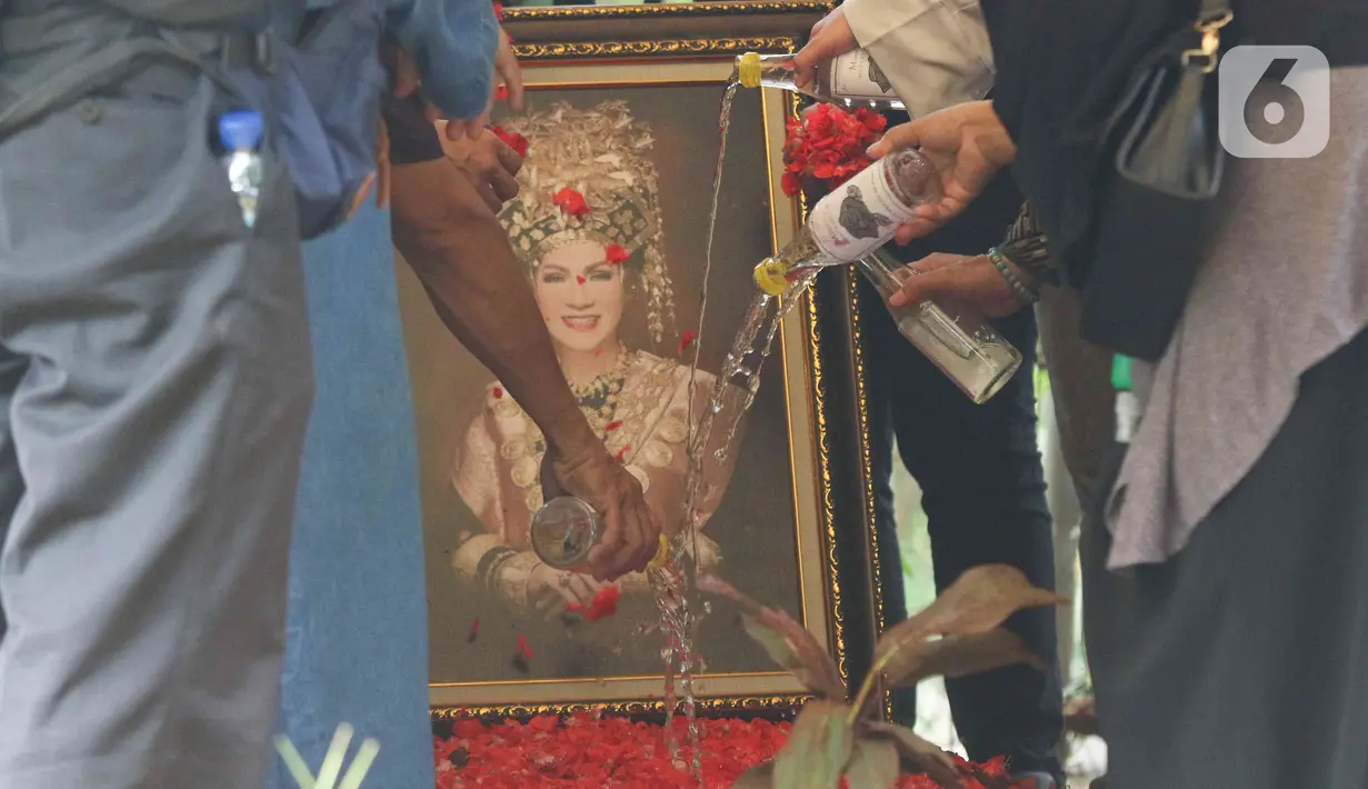 Kerabat dan keluarga menyiramkan air di makam Dedi Yuliardi Ashadi atau Dorce Gamalama di TPU Bantar Jati, Bambu Apus, Jakarta, Rabu  (16/2/2022). Dorce menghembuskan nafas terakhir di RSPP Simprug, Jakarta Selatan, Rabu (6/2) pukul 07.00 WIB. (Liputan6.com/Herman Zakharia)