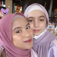 Sienna tampil mengenakan kerudung model pashmina model plisket warna ungu yang serasi dengan Nesyana. Sienna pun mengenakan ciput putih dan busana warna ungu. Credit: (@nesyanabila)
