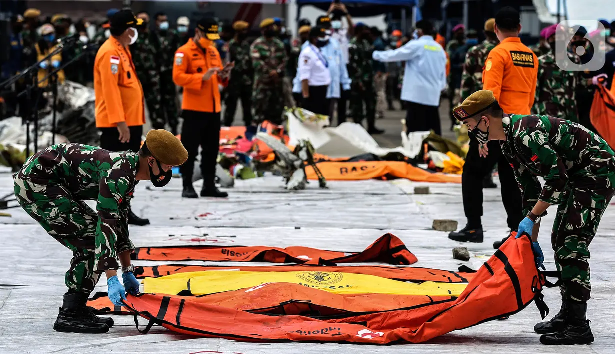 Prajurit TNI meletakan kantong jenazah korban pesawat Sriwijaya Air SJ-182 yang jatuh di perairan Pulau Seribu, di Dermaga JICT, Jakarta, Selasa (12/1/2021). Tim SAR kembali membawa secara berkala temuan korban dan puing pesawat Sriwijaya Air SJ 182. (Liputan6.com/Johan Tallo)