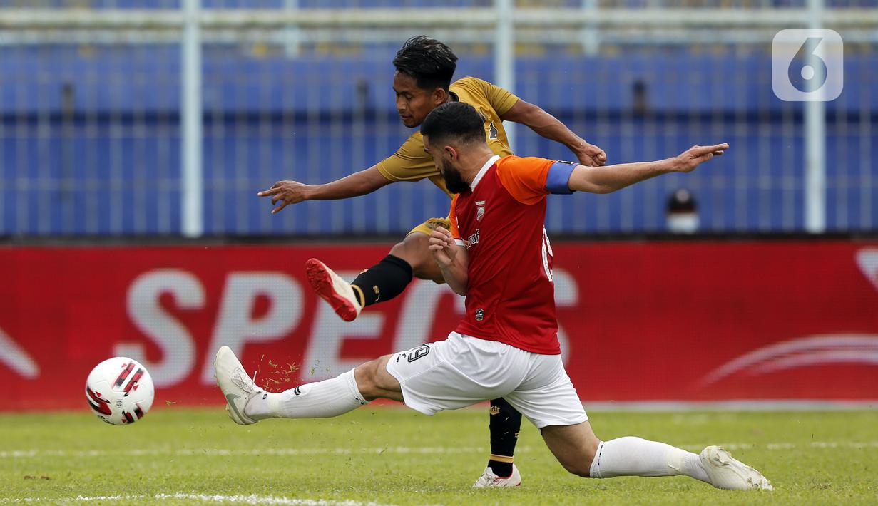 Pemain Borneo FC Samarinda Javlon Guseynov berusaha menghalau bola tembakan pemain Bhayangkara Solo FC Andik Vermansah dalam pertandingan babak penyisihan Piala Menpora 2021 di Stadion Kanjuruhan, Malang, Jawa Timur, Senin (22/3/2021). (Bola.com/Arief Bagus)