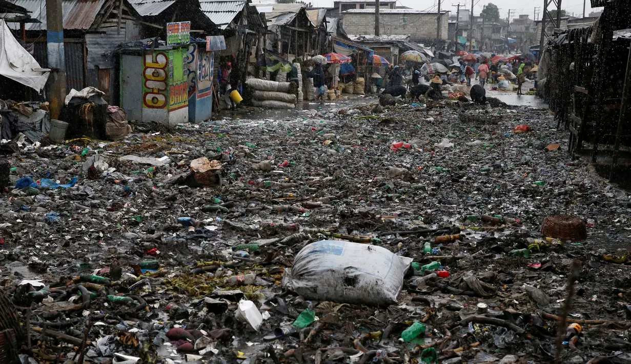 Sejumlah warga membersihkan jalan yang tertutup sampah usai Badai Matthew menghantam Port-au-Prince di Haiti (4/10). Keganasan Badai Matthew ini telah meluluhlantakkan wilayah Haiti. (REUTERS/Carlos Garcia Rawlins)