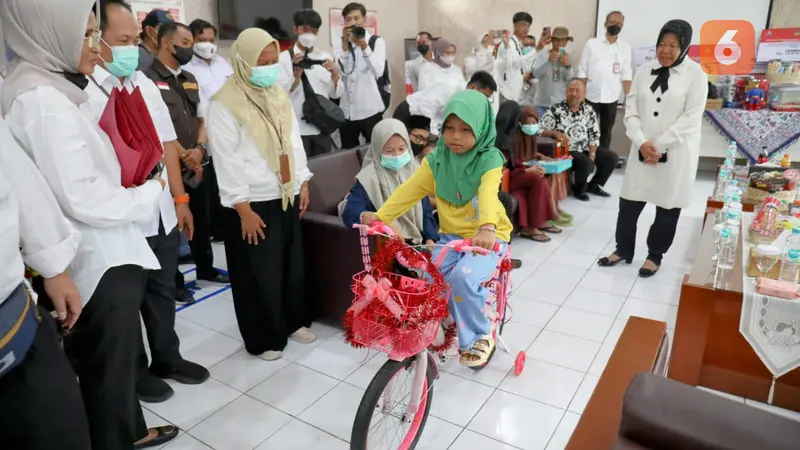 Kemensos Tri Rismaharini di Kabupaten Sukabumi saat berikan sepeda kepada salah satu anak yang menderita penyakit berat betha thalasemia, Aisyah Azzahra (9) asal Lebak Banten (Liputan6.com/Fira Syahrin).
