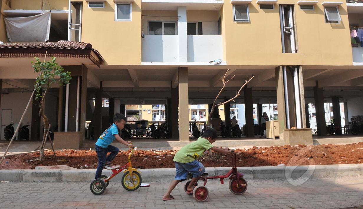 Anak kecil bermain sepeda di halaman Rusunawa Muara Baru, Jakarta, Kamis (21/05/2015). Fasilitas rusunawa muara baru akan di tambah dan diperlengkap seperti pembangunan Ruang Publik Terpadu Ramah Anak (RPTRA). (Liputan6.com/Herman Zakharia)