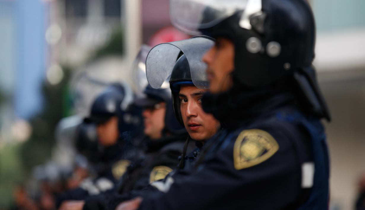 Petugas kepolisian berjaga saat unjuk rasa sejumlah warga Meksiko menolak kenaikan harga BBM, Mexico City, Meksiko (9/1). (AP Photo/Marco Ugarte)