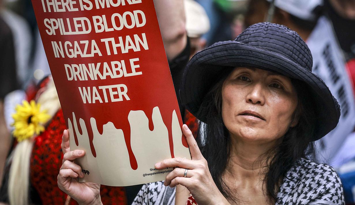 Sementara itu, sebuah studi terbaru yang diterbitkan jurnal medis The Lancet Global Health mengungkap, jumlah korban tewas di Gaza selama 15 bulan pertama operasi militer Israel sejak Oktober 2023 mencapai lebih dari 75.000 orang. Tampak dalam foto, para demonstran pro-Palestina membawa bendera, spanduk, dan plakat saat mereka berbaris berunjuk rasa di jalanan kota Sydney, Australia, Minggu 22 Februari 2026. (DAVID GRAY/AFP)