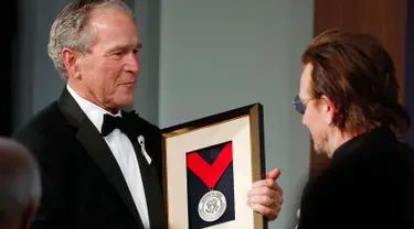 Presiden AS ke-43 George W. Bush (kiri) memberikan medali Distinguished Leadership kepada vokalis U2 Bono selama gala untuk Forum Kepemimpinan di Institut George W. Bush di Dallas, AS (19/4). (AP Photo/Brandon Wade)