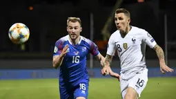 Gelandang Islandia, Runar Mar Sigurjonsson, beradu cepat dengan bek Prancis, Lucas Digne, pada laga Kualifikasi Piala Eropa 2020 di Reykjavik, Sabtu (11/10). Islandia kalah 0-1 dari Prancis. (AFP/Jonathan Nackstrand)