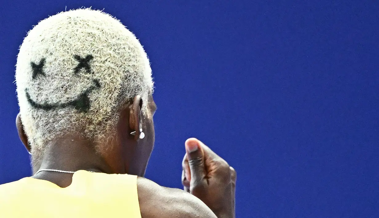Rambut pelari Jamaika, Janieve Russell bergambar emoji wajah tersenyum saat berkompetisi dalam nomor lari gawang 400 meter Olimpiade Paris 2024 di Stade de France, Paris, Prancis, 6 Agustus 2024. (AFP/Jewel Samad)