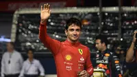 Pembalap Ferrari Charles Leclerc melambaikan tangan kepada penonton setelah meraih posisi terdepan dalam sesi kualifikasi jelang balapan Formula 1 atau F1 GP Singapura di Sirkuit Marina Bay Sirkuit Marina Bay Street, Sabtu (2/10/2022) malam WIB. (Lillian SUWANRUMPHA / AFP)