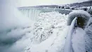 Pengunjung mengabadikan pemandangan Horseshoe Falls di Air Terjun Niagara yang membeku di Ontario, Kanada, Jumat (29/12). Cuaca dingin melanda sebagian besar wilayah utara Amerika Serikat di akhir tahun ini. (Aaron Lynett/Canadian Press via AP)