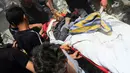 Puluhan warga menandu seorang wanita yang menjadi korban ledakan bom mobil (REUTERS/Yousef Albostany).