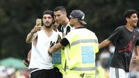 Seorang suporter Juventus berselfie dengan Cristiano Ronaldo selama pertandingan persahabatan antara Juventus A dan tim B, di Villar Perosa, Italia utara, (12/8). Suporter tersebut masuk ke lapangan pada babak pertama. (AP Photo/Antonio Calanni)