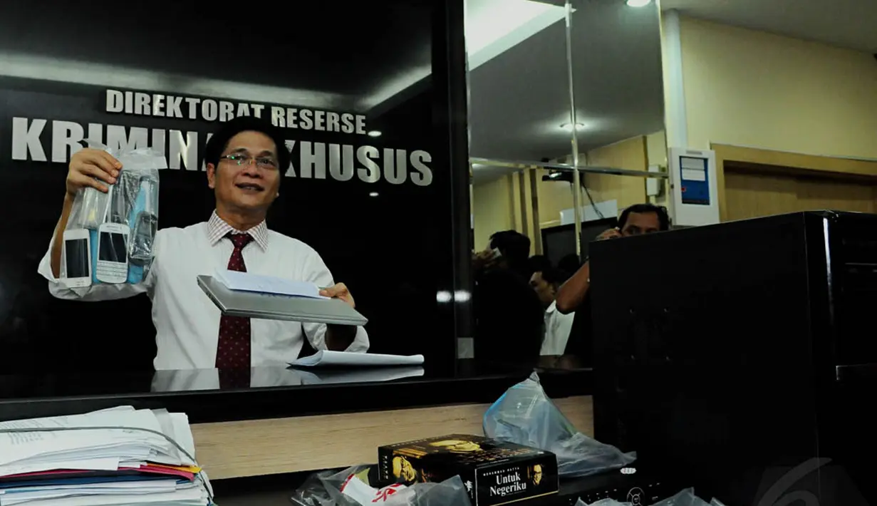 Petugas menunjukkan beberapa barang bukti terkait kasus dugaan pemerasan oleh akun Twitter @Triomacan2000, Jakarta, Senin (3/11/2014). (Liputan6.com/Andrian M Tunay)