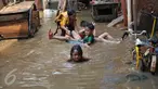 Anak-anak bermain di lokasi banjir yang merendam kawasan Kampung Pulo, Jakarta, Selasa (17/11). Kawasan di sepanjang aliran Kali Ciliwung terendam banjir sejak kemarin akibat Bendungan Katulampa yang sudah mencapai siaga satu (Liputan6.com/Gempur M Surya)