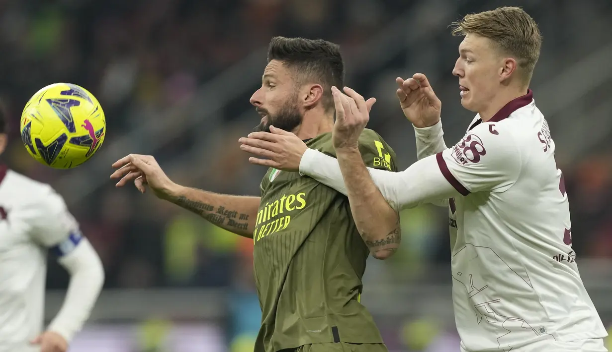 Penyerang AC Milan Prancis Olivier Giroud berebut bola dengan bek Torino Perr Schuurs dalam duel pekan ke-22 Serie A 2022-2023, Sabtu (11/2/2023) dini hari WIB. Gol tunggal Olivier Giroud membuat Milan menang 1-0. (AP Photo/Antonio Calanni)