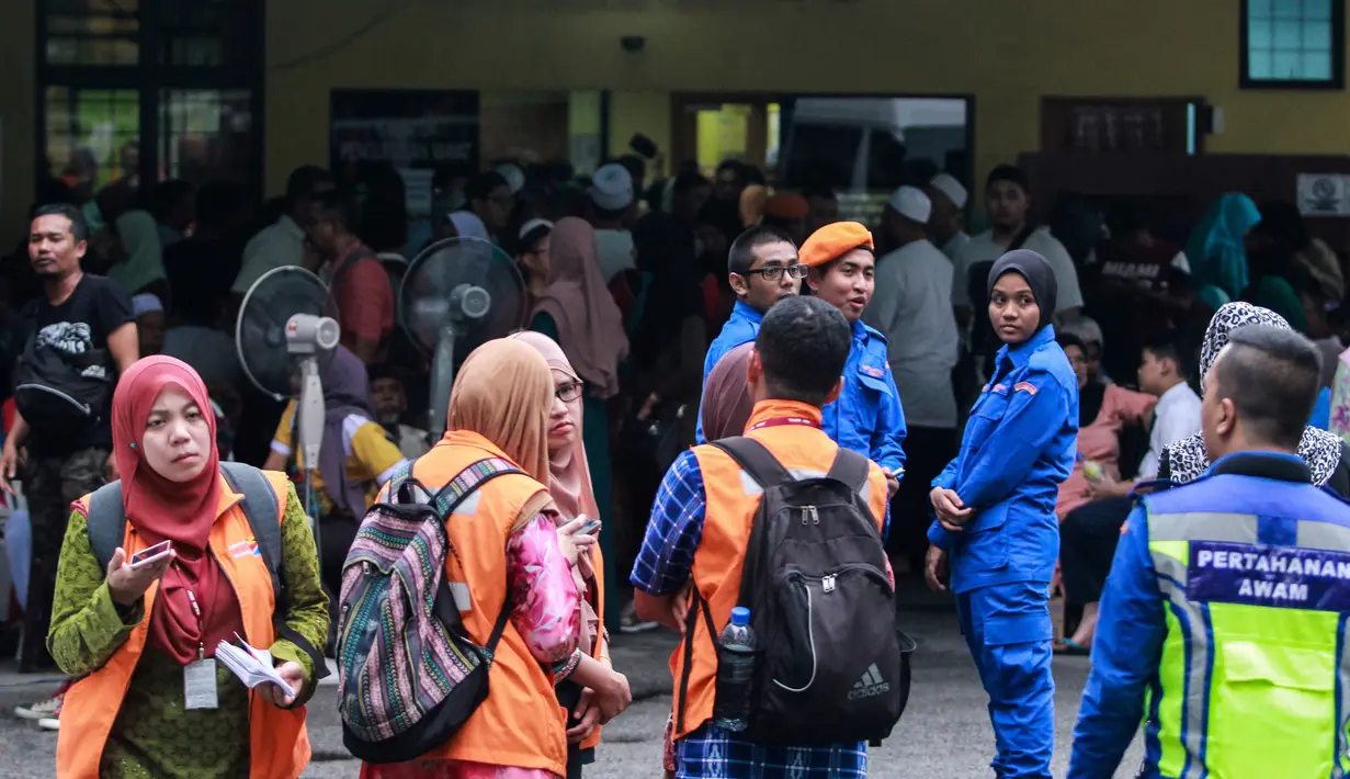 Sejumlah keluarga dan kerabat berkumpul di dekat ruang forensik Rumah Sakit Kuala Lumpur menunggu  jenazah korban kebakaran sekolah agama Darul Quran Ittifaqiyah, Malaysia (14/9). (AFP Photo/Sadiq Asyraf)