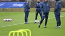 Pelatih Chelsea, Graham Potter (kedua kanan) berbicara dengan anggota staf pelatihnya selama sesi latihan tim di fasilitas latihan Chelsea di Cobham di Stoke D'Abernon, London (6/3/2023). Borussia Dortmund hanya butuh hasil imbang untuk memastikan ke babak perempatfinal Liga Champions.(AFP/Glyn Kirk)