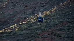 Puluhan wisatawan terperangkap di dua kereta gantung menuju puncak Gunung El Teide (3.718 meter) di Taman Nasional El Teide, Pulau Canary, Spanyol, Rabu (15/3). Belum diketahui penyebab macetnya kabel untuk menarik kereta gantung itu. (Desiree Martin/AFP)