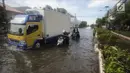 Pengendara mendorong motornya saat melintasi banjir rob di kawasan Muara Baru, Jakarta, Rabu (6/11). Air laut pasang yang terjadi mengakibatkan sejumlah wilayah dilokasi tersebut terendam banjir rob. (Liputan6.com/Faizal Fanani)