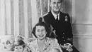 Prince Charles berpose dengan Princess Anna yang saat itu masih berusia 2 bulan. Ia berada di dekapan Princess Elizabeth dan Prince Phillip. Foto ini diambil pada 1950. (Cosmopolitan)