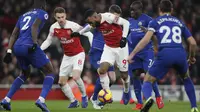 Striker Arsenal, Alexandre Lacazette, berusaha melewati pemain Chelsea pada laga Premier League di Stadion Emirates, Sabtu (19/1). Arsenal menang 2-0 atas Chelsea. (AP/Frank Augstein)