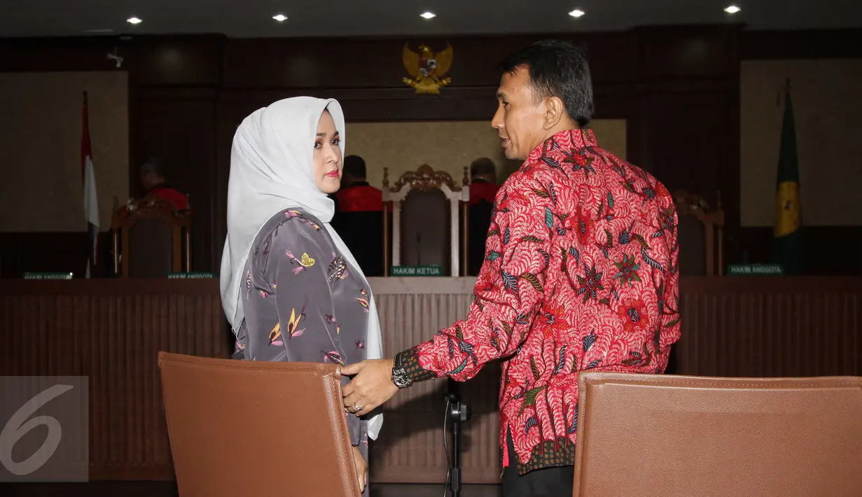 Gatot Pujo Nugroho dan istrinya Evy Susanti saat jalani sidang perdana di Pengadilan Tipikor Jakarta, (23/12). Gatot dan Evy didakwa dalam dua perkara yakni suap hakim dan panitera PTUN Medan dan suap eks Sekjen NasDem. (Liputan6.com/Helmi Afandi)