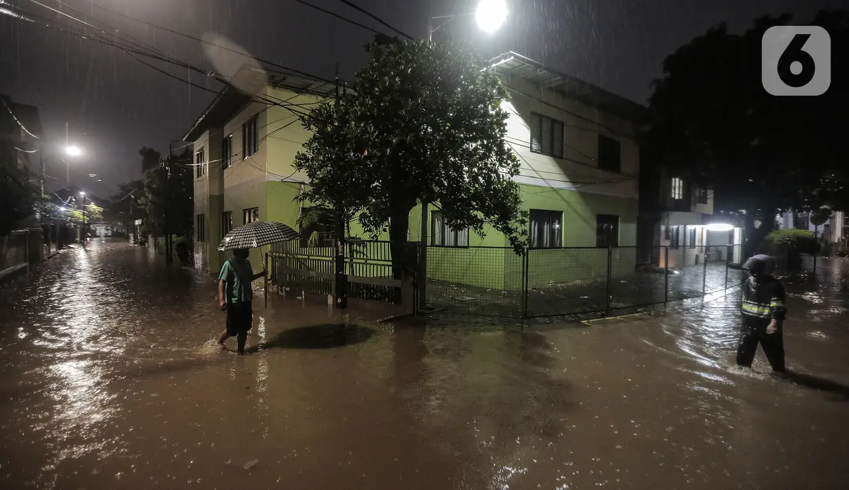 Warga melewati rumah yang tergenang banjir di jalan Bank, Jakarta Selatan, Selasa (4/10/2022). Hujan yang mengguyur wilayah Ibu Kota Jakarta mengakibatkan banjir menggenangi kawasan Kemang, Jakarta. (Liputan6.com/Johan Tallo)