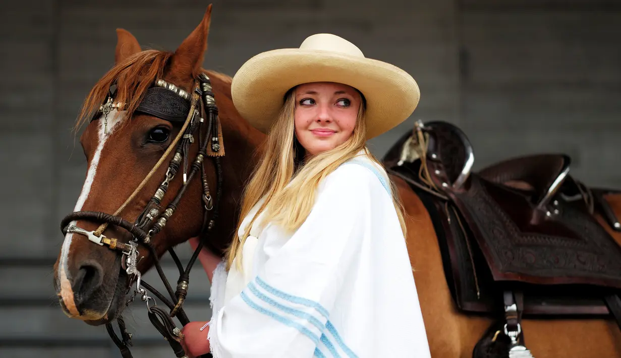 Seorang wanita menuntun kuda untuk mengikuti festival  Calgary Stampede di Calgary , Alberta , Kanada, (9/7). Acara ini telah ada sejak abad ke-19 dan telah menarik banyak pengunjung.( REUTERS / Todd korol)