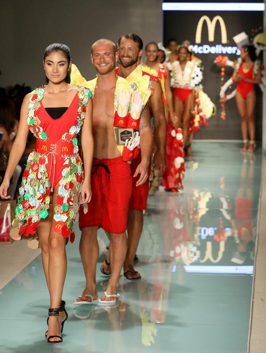 Model berjalan di atas runaway memperagakan koleksi yang diberi nama McDCouture Collection di Miami Swim Week, 20 Juni 2017. Koleksi baju renang tersebut dikreasikan dengan ribuan kemasan makanan cepat saji McDonald's. (ALEXANDER TAMARGO/GETTY IMAGES/AFP)