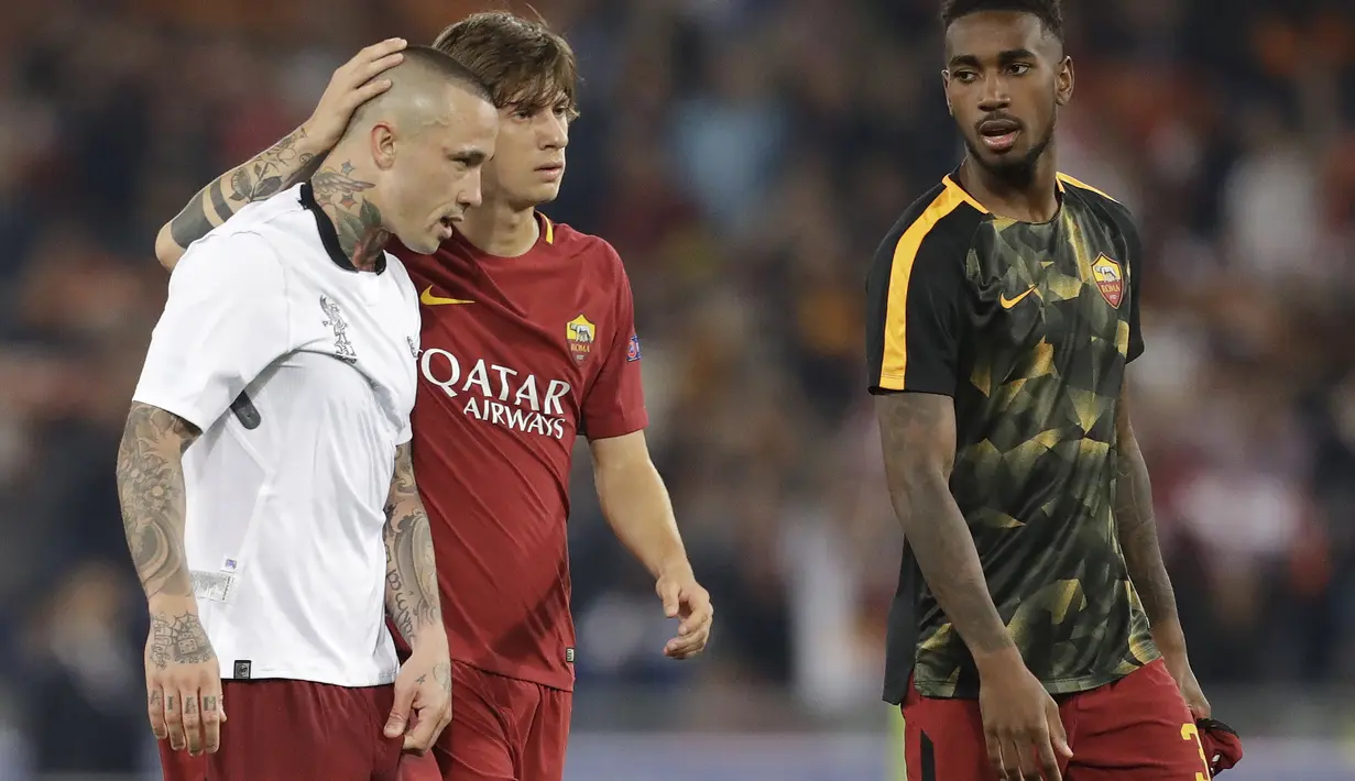 Radja Nainggolan (kiri) menerima pelukan dari rekannya Mirko Antonucci setelah laga melawan Liverpool pada semifinal Liga Champions di Olympic Stadium,(2/4/2018). AS Roma gagal ke final setelah kalah agregat dari Liverpool 6-7. (AP/Andrew Medichini)